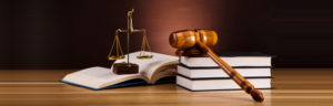A gavel on books beside a judging scale