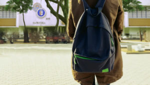 A person with a backpack standing in a campus