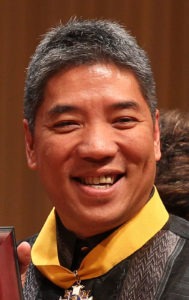 A headshot picture of a person with a medal