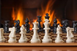 A chess board in front of a fireplace