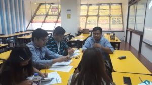 A tutor teaching students in a classroom with AHEAD's tarps covering the windows