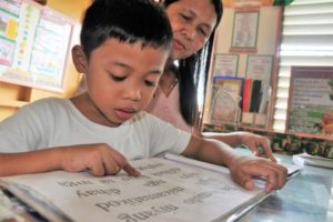 A teacher teaching a student how to read