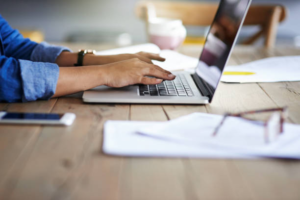 A person typing on their laptop