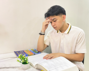 A frustrated student looking at their textbook