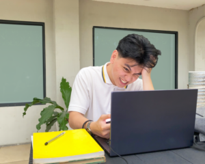 A very stressed student looking at a laptop